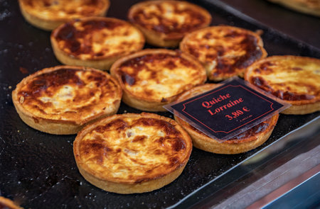 Selection of freshly baked quiche lorraine savory tarts with bacon, egg and cheese on display at an artisanal bakery in the old town of Nice, Franceの写真素材