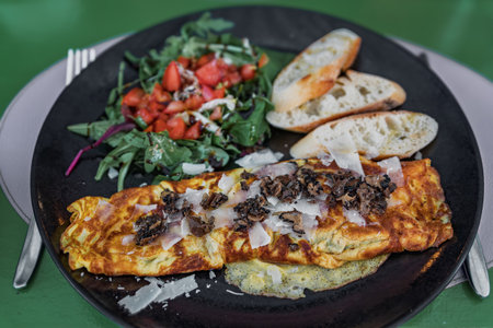 An omelet with shaved black truffles served with a side salad and toast at an Italian restaurant in...