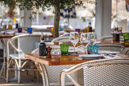 Al fresco tables waiting for customers at an outdoor waterfront beach restaurant in Nice, South of...
