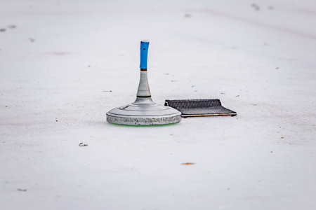 Traditional Swiss winter game, Eisstock sport or Bavarian curling, a stock sits on an ice rink,...