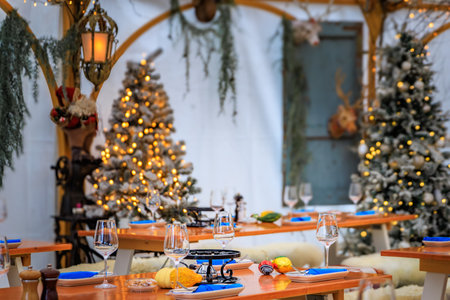 Rustic winter wonderland: wooden tables, cozy fur throws, Christmas trees and festive touches await diners at a restaurant in Zurich, Switzerlandの写真素材