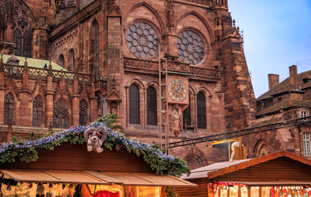 Decorated festive chalet stall with the famous Notre Dame Cathedral in the background, a magical scene at the Strasbourg Christmas Market in Franceの写真素材