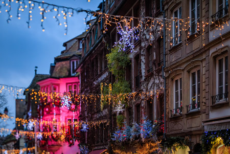 Strings of festive lights illuminate a street with half timbered houses in the Grande Ile district of Strasbourg, France, during the Christmas Marketの写真素材