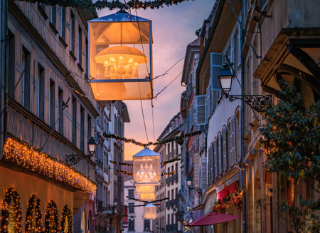 Strings of festive lights illuminate a street with half timbered houses in the Grande Ile district of Strasbourg, France, during the Christmas Marketの写真素材