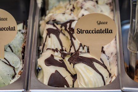 Artisanal vanilla and chocolate stracciatella gelato in a tub on display at a gelateria ice cream...