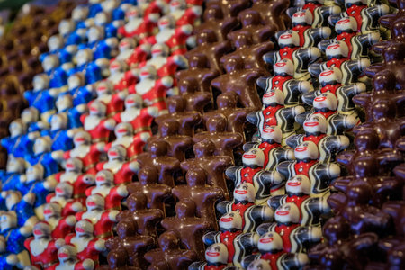 Display of festively decorated colorful artisanal chocolate figurines shaped like a gingerbread man, the Strasbourg Christmas Market in Franceの写真素材
