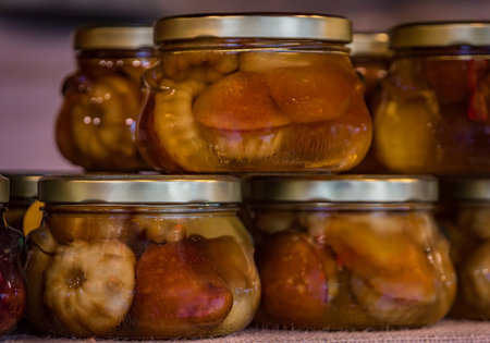Jars of mini Baba au Rhum or Rum Baba cakes soaked in pear Poire and damson plum Quetsche liqueurs, Christmas market in Colmar, Franceの写真素材