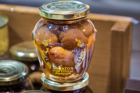 Strasbourg, France - December 14, 2024: Jars of chestnuts soaked in cognac at a Christmas market stand, a holiday shopping experienceのeditorial素材