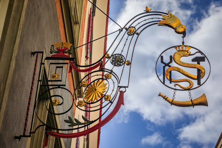 Ornate historic gilded wrought iron medieval guild sign for the smiths guild featuring a snake, a hammer and a horn, Old Town of Zurich, Switzerlandの写真素材