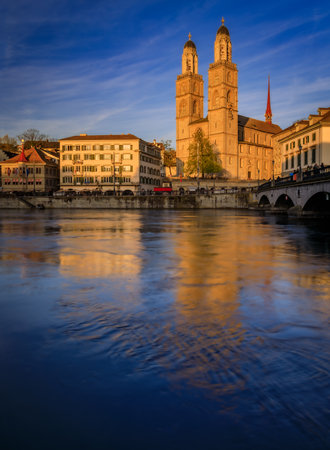 Cityscape with classic buildings on Limmat River in Altstadt Old Town and iconic Grossmunster twin-towered Romanesque cathedral, Zurich, Switzerlandの写真素材