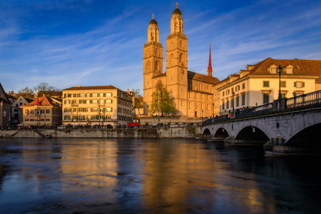 Cityscape with classic buildings on Limmat River in Altstadt Old Town and iconic Grossmunster twin-towered Romanesque cathedral, Zurich, Switzerlandの写真素材