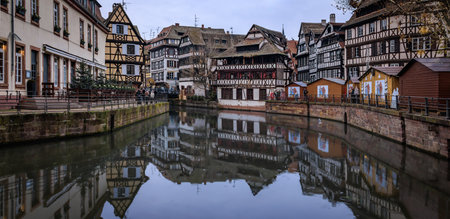 Strasbourg, France - December 14, 2024: Half timbered houses in Petite France reflecting in the water, festive decorations during the Christmas Marketのeditorial素材