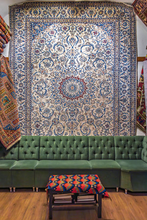 Cozy interior of a traditional carpet shop in the Grand Bazaar with a beautiful carpet a wall and a divan in a behind-the-scenes in Istanbul, Turkeyの写真素材