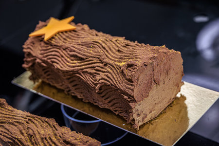 Rich chocolate Buche de Noel Christmas or Yule Log cake on display, a traditional festive holiday...