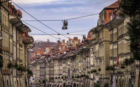 Festive pine trees hang from medieval facades along the historic Kramgasse in the Altstadt or Old Town during Christmas market in Bern, Switzerlandの写真素材