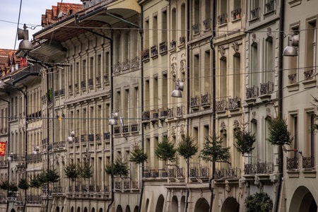 Festive pine trees hang from medieval facades along the historic Kramgasse in the Altstadt or Old Town during Christmas market in Bern, Switzerlandの写真素材