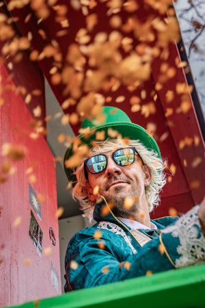 Zug, Switzerland - March 1, 2025: Bright confetti floats in the air as costumed revellers celebrate at the traditional Fasnacht winter carnival paradeのeditorial素材