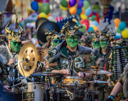 Bern, Switzerland - March 1, 2025: Guggenmusik marching brass band in colorful costumes and face paint performs at the Fasnacht winter carnival paradeのeditorial素材