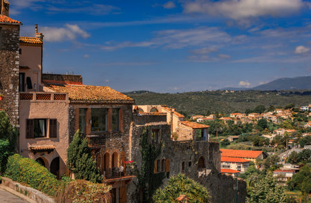 Stone villas with terracotta roofs built into a lush hillside, overlooking a verdant valley and...