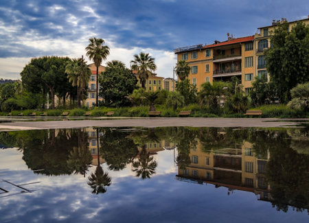 Reflecting fountain on Promenade du Paillon, surrounded by beautiful historic buildings and green...