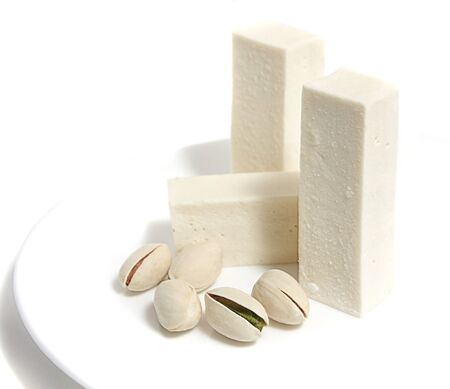 Vanilla pastila and pistachios on a white plateの写真素材