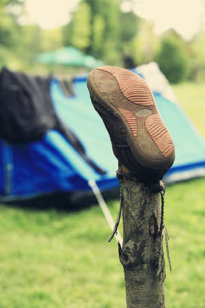 shoes with laces on a stick to dry by the fireの写真素材
