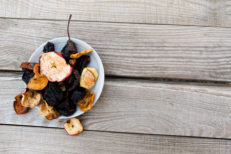 Dried fruits in a plate on wooden tableの写真素材