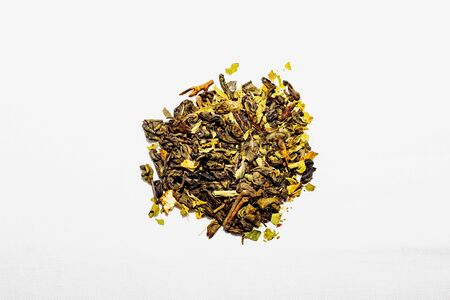 Green tea isolated on a white cotton cloth. Dried japanese green tea over white background. A pile of dry green tea on a white background. Top view, isolate, close up.の写真素材