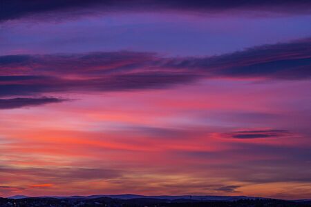 Bright red-blue-orange sunset in the sky with clouds. Beautiful colorful dawn above the earth....