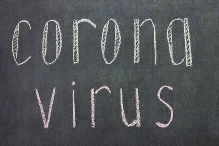 The inscription Corona virus on a black board with white chalk. Epidemic concept. Background, soft focus.の写真素材