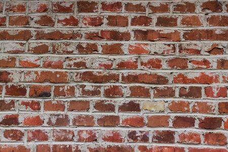 Old weathered red brick wall as a background. Repeating red brick wall textures are commonly found...