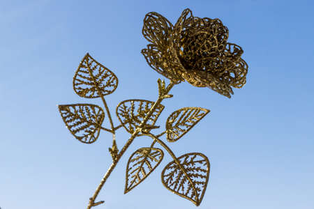 Gold decorative openwork flowers on a blue sky background. Texture for design, copy space, postcardの写真素材