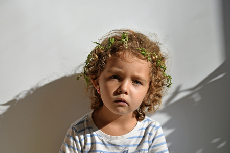 Portrait of little girl with curls on white background. The face of the childの写真素材