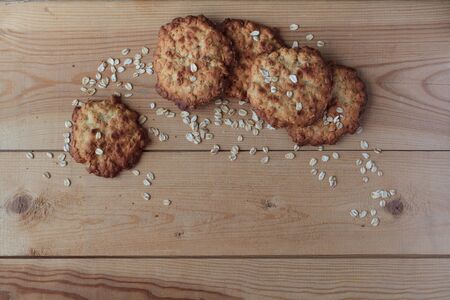 Several traditional oatmeal cookies, sprinkled with oatmeal flakes, are on the three wooden boards. Space text for menu.の写真素材