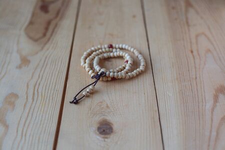 Rosary of wood are on the light wooden table.の写真素材