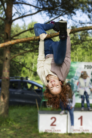 Pretty girl doing exercise upside down on open airの写真素材
