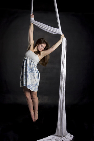 Aerialist woman doing some flexibility and strength tricks on silksの写真素材