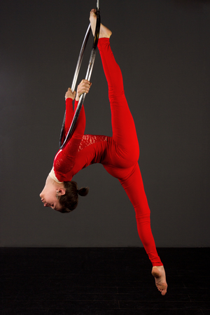 Attractive aerialist woman exercising on aerial ring (lyra)の写真素材