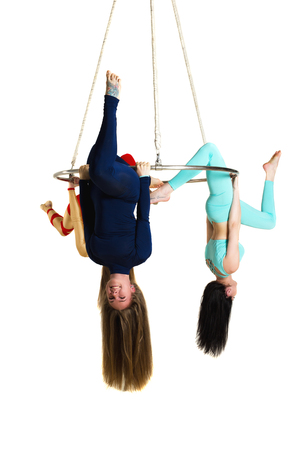 Young woman`s trio doing som acrobatic tricks on aerial lusterの写真素材