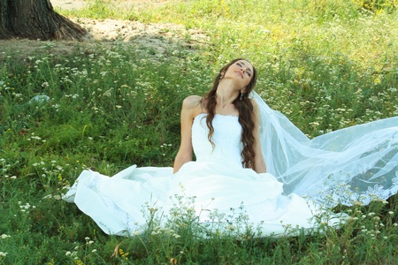 Beautiful bride siiting on grass.の写真素材