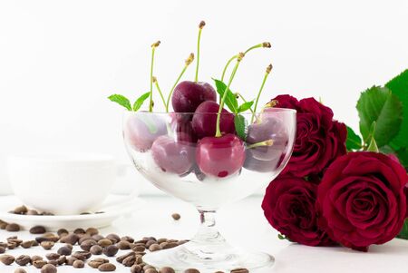Fresh fruits, flowers, cup of hot coffee on a white table.の写真素材