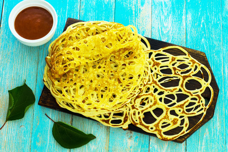 Lace pancakes on a blue background.の写真素材