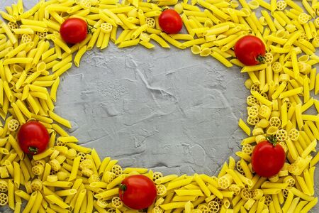 Pasta, tomatoes on a gray background. View from above.の写真素材