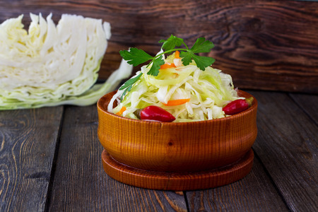 Pickled cabbage. Wooden background.の写真素材
