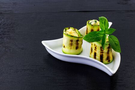 Rolls of courgettes. Black background.の写真素材