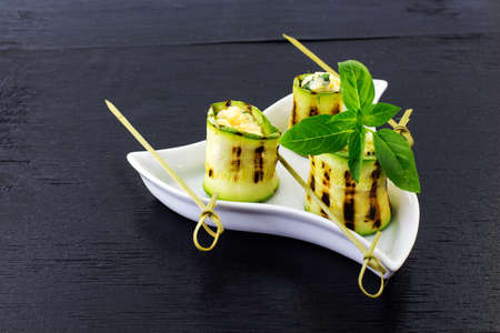 Rolls of courgettes. Black background.の写真素材