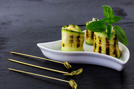 Rolls of courgettes. Black background.の写真素材