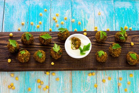 Falafel on a wooden board. Blue background. View from above.の写真素材
