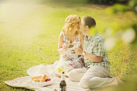 Beautiful married couple having romantic picnic outdors on summer sunny dayの写真素材