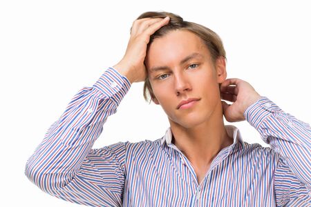 Handsome young man looking at camera and touching his hair over white background Handsome young man looking at camera and touching his hair over white background